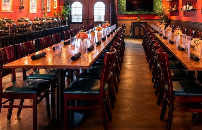 Long rows of wooden tables set for a banquet at San Diego’s Best Pizza.